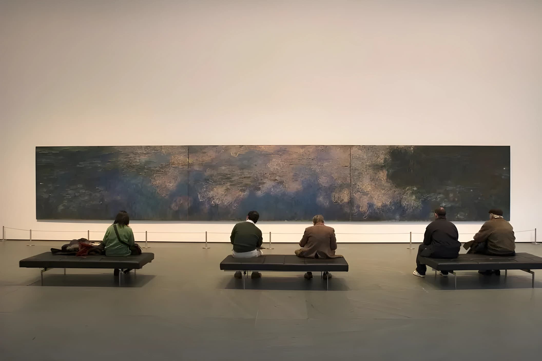 Museum visitors seated in front of Claude Monet’s Water Lilies at The Museum of Modern Art